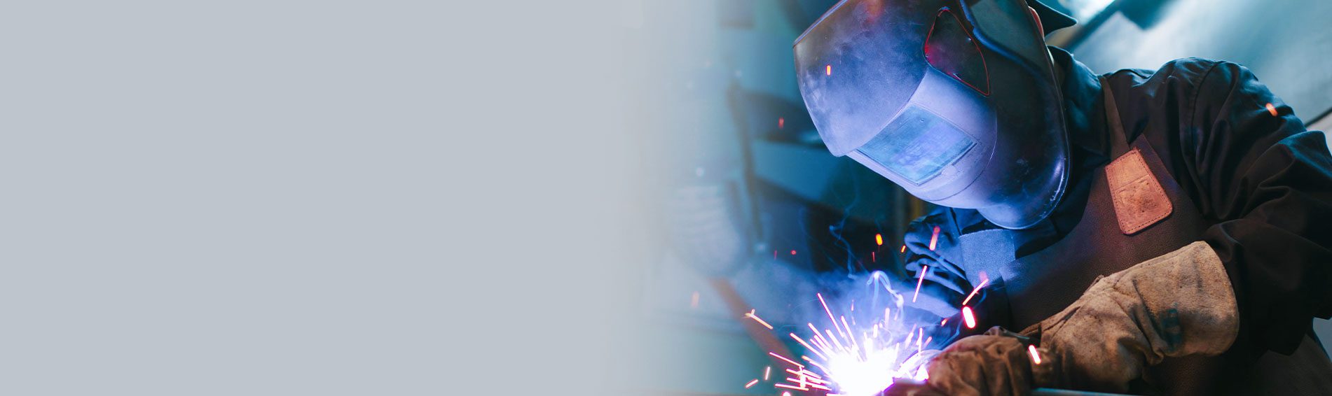  welding mask and looking with burning eyes while leaning on metal part in factory shop